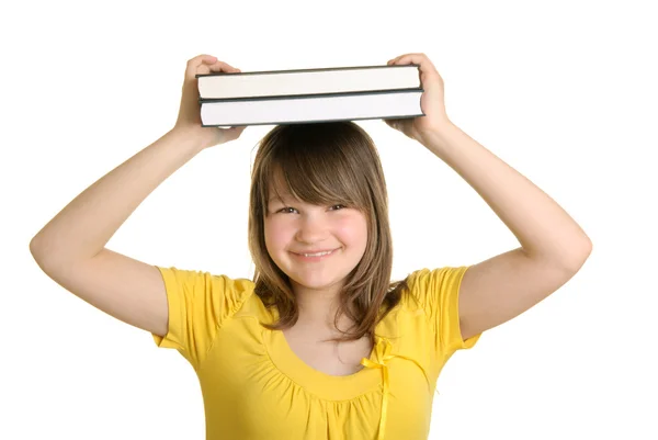 Leende flicka håller böcker på huvud — Stockfoto