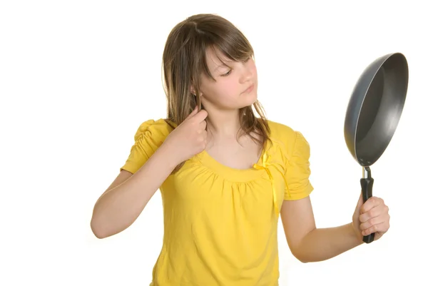 Girl looks at bottom of frying pan — Stock Photo, Image