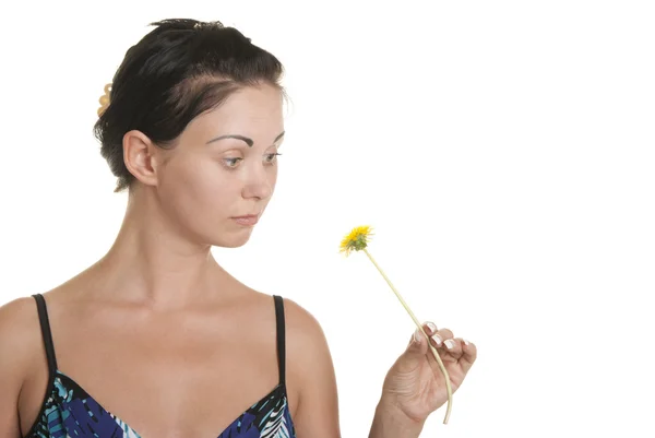 Woman with surprise looks at flower — ストック写真
