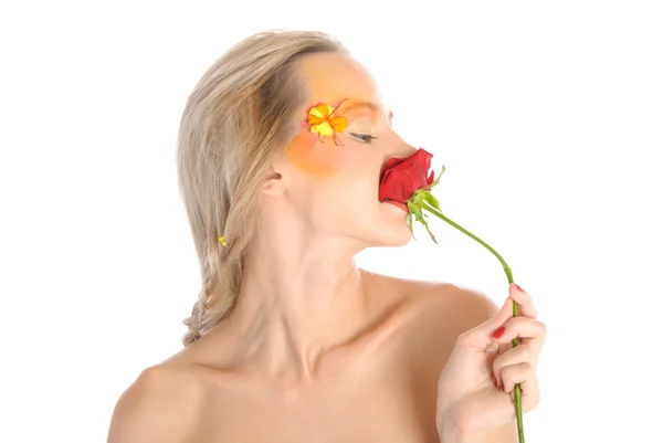 Mladá žena kousnutí květ — Stock fotografie