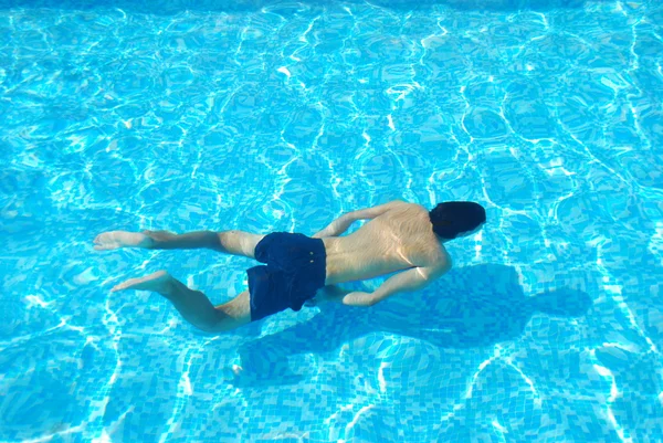 Genç adam suyun altında yüzüyor. — Stok fotoğraf