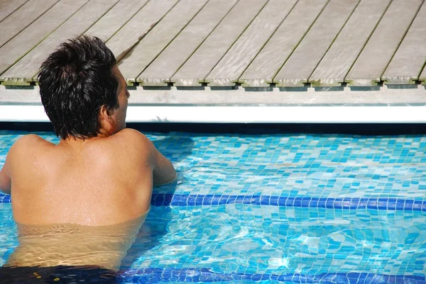 Jovem relaxante na beira da piscina — Fotografia de Stock
