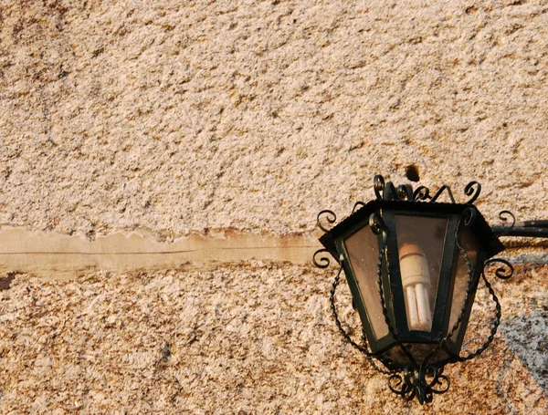 Старый фонарь на фоне гранитной стены — стоковое фото