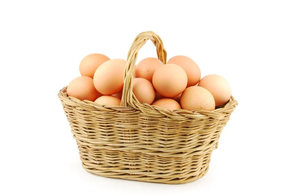 Ägg i en flätad korg på vit — Stockfoto