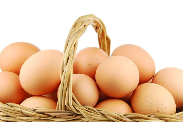 Primo piano di uova in un cesto di vimini su bianco — Foto Stock