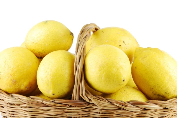 Närbild av citroner i en flätad korg på vit — Stockfoto