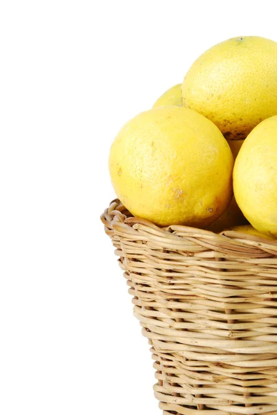Крупный план лимонов в плетеной корзине на белом — стоковое фото