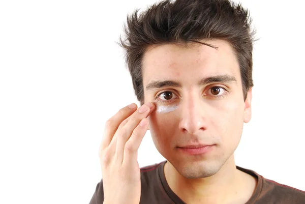 Pohledný muž použitím oční krém — Stock fotografie