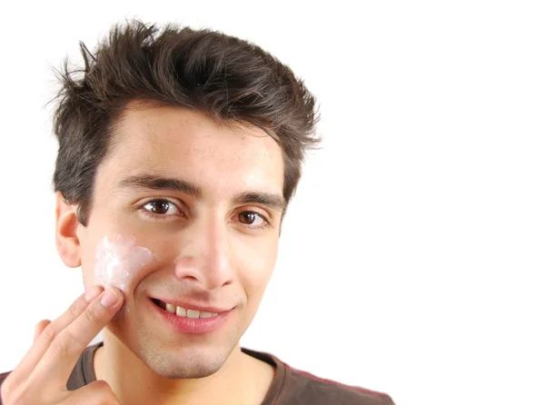 Sorrindo homem aplicando creme facial — Fotografia de Stock