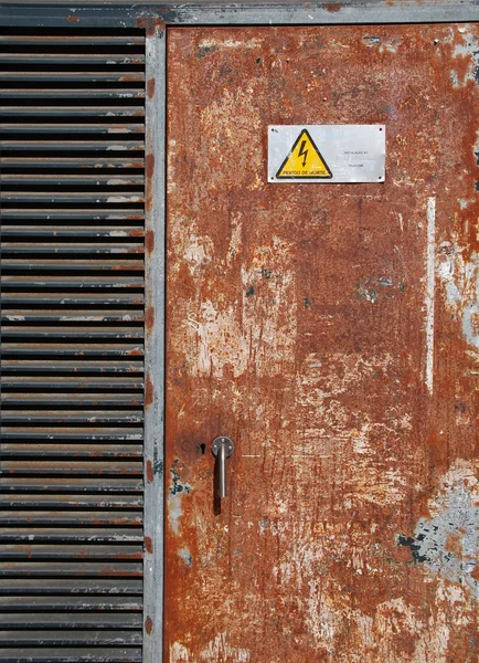 Magas feszültségű jel-ra egy rozsdás ajtó — Stock Fotó