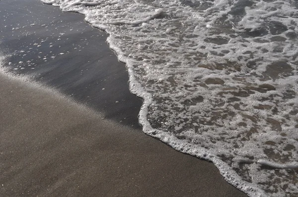 Schuim op zand — Stockfoto