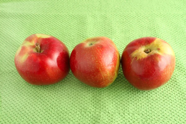 Яблочное трио на зеленом тканевом фоне — стоковое фото