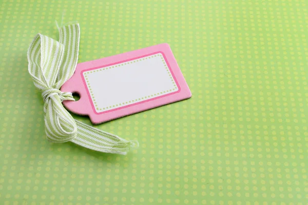 Etiqueta rosa em branco no verde — Fotografia de Stock