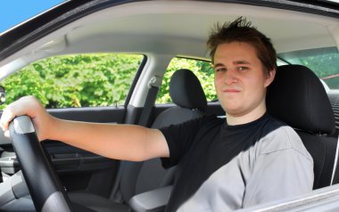 Teenage male behind the driver's wheel clipart