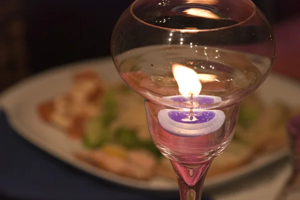Зажженная свеча над столом — стоковое фото
