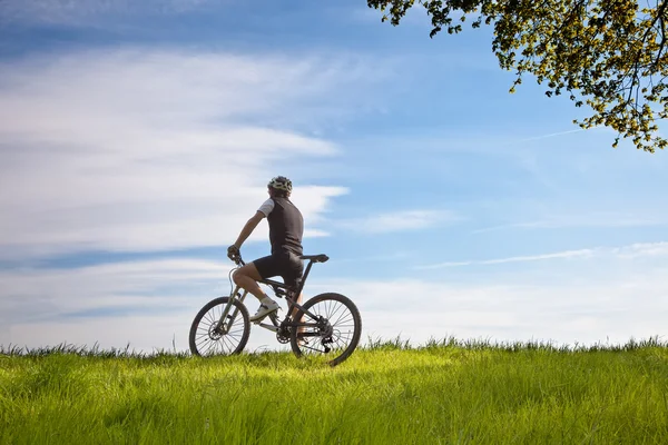 Homme sur un vélo dans un champ — Photo