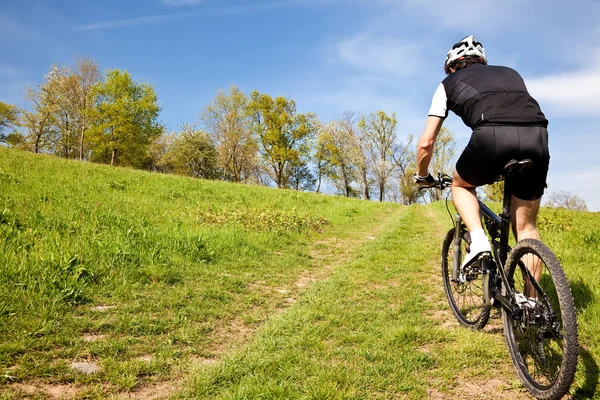 Ciclista de montaña montando cuesta arriba — Foto de Stock