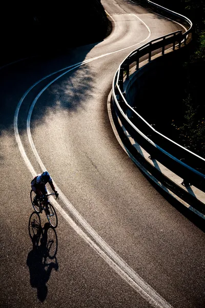 Fietser rijdend langs een bergweg — Stockfoto