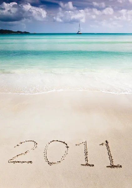 stock image 2011 write in the sand of a tropical beach