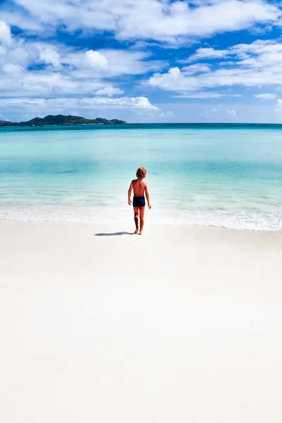 Niño caminando en una playa tropical —  Fotos de Stock