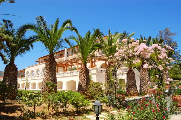 Hotelgebouw versierd met bloemen en palmen — Stockfoto