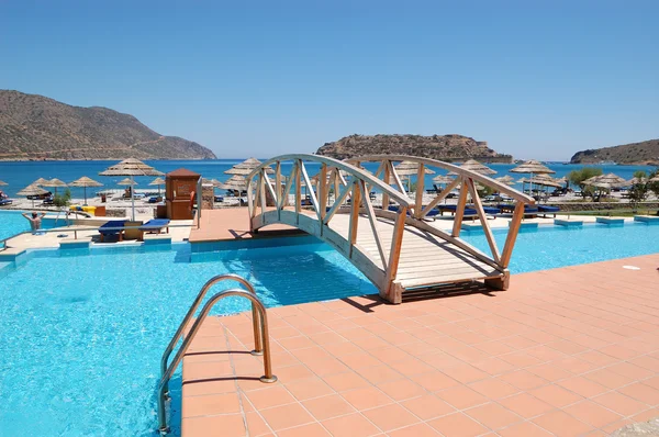 Bridge over swimming pool to the beach at luxury hotel, Crete, G — Stock Photo, Image
