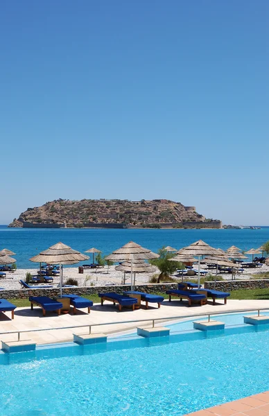 Zwembad en strand met uitzicht op het eiland spinalonga, Kreta, — Stockfoto