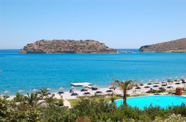 Beach of luxury hotel with a view on Spinalonga Island, Crete, clipart