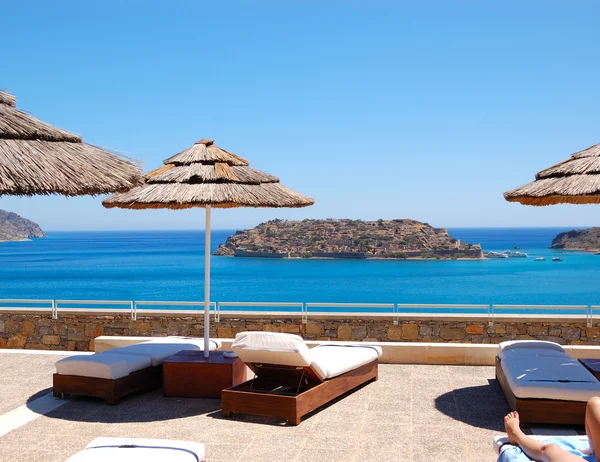Sunbeds at luxury hotel with a view on Spinalonga Island, Crete, — Stock Photo, Image