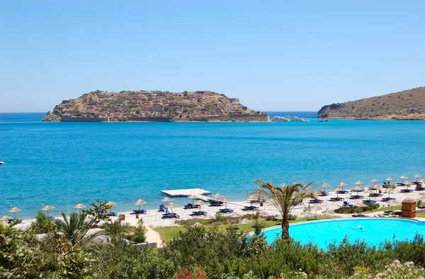 Beach of luxury hotel with a view on Spinalonga Island, Crete, — Stock Photo, Image