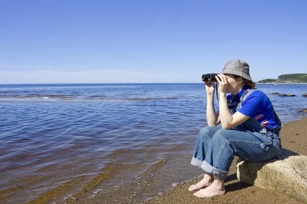 The girl with the binoculars. — Stock Photo, Image