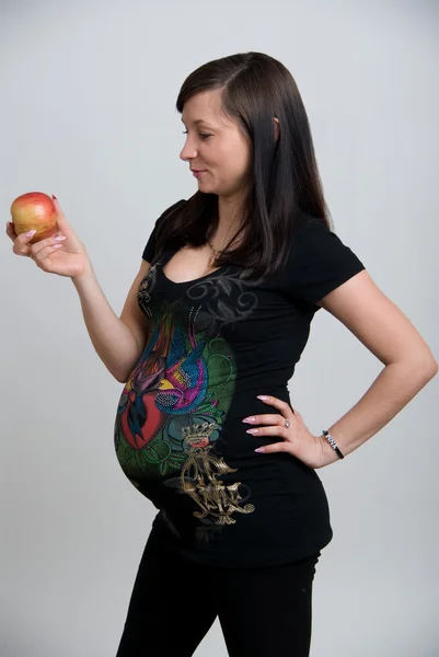 Беременная женщина с фруктами на белом фоне — стоковое фото