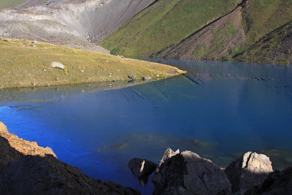 Horské jezero v pozadí s vysokou horu — Stock fotografie