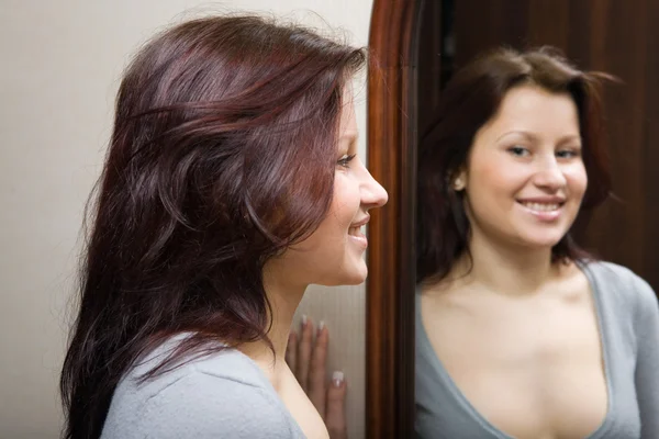 Дівчина дивиться на себе у дзеркало — стокове фото