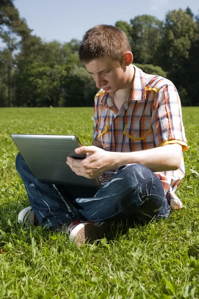 Man using laptop in summer park — Stock Photo, Image