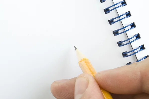 Pencil in hand and notebook — Stock Photo, Image