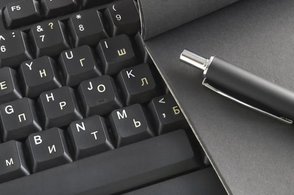 Notatnik i długopis na klawiaturze — Zdjęcie stockowe
