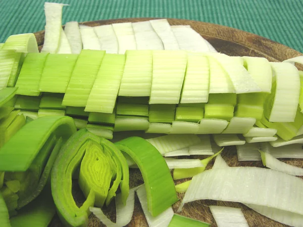 Porro verde affettato su un piatto di legno — Foto Stock