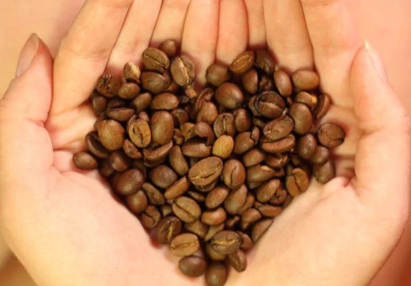 Sosteniendo en las manos granos de café — Foto de Stock