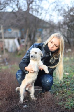 küçük beyaz bir köpek ile oynanan kız