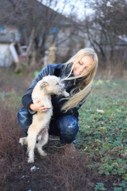 sarışın kız küçük beyaz bir köpek ile oynadı