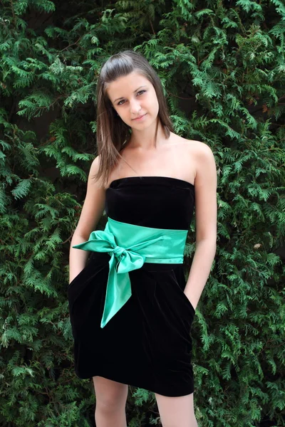 Dívka v černých šatech s zelených luk — Stock fotografie