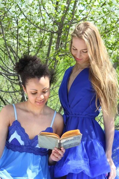Två flickor i blått i trädgården — Stockfoto