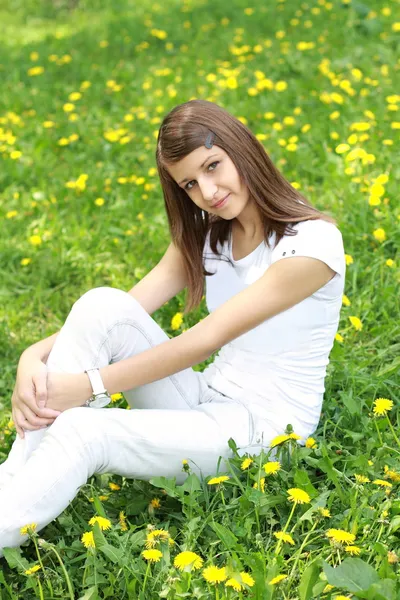 Girl on the glade with dandelions — Stock Photo, Image