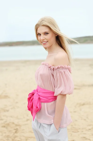 Krásná blonďatá usmívající se dívka na pláži — Stock fotografie