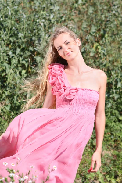 Flicka i rosa klänning med rosor — Stockfoto