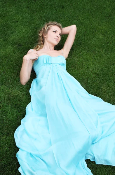 Ξανθιά κοπέλα στο μακρύ φόρεμα στον κήπο — Φωτογραφία Αρχείου