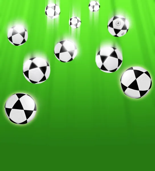 Pelotas de fútbol sobre un fondo verde — Foto de Stock