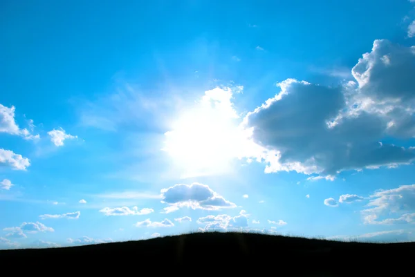 Die hinter Wolken glitzernde Sonne — Stockfoto