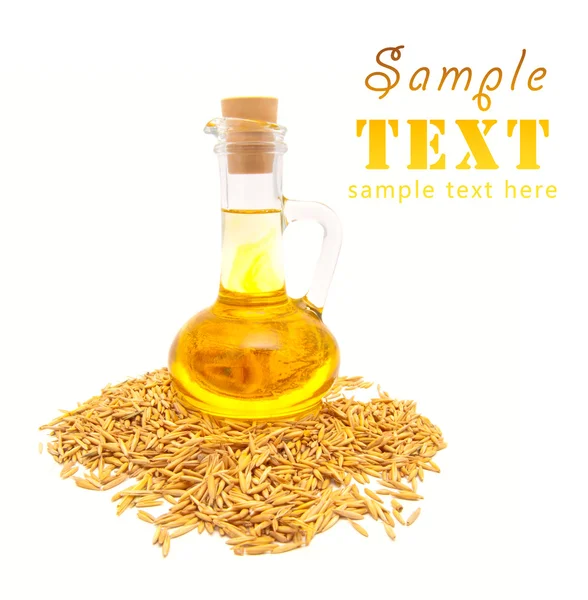 Botella pequeña con aceite vegetal y granos de trigo —  Fotos de Stock